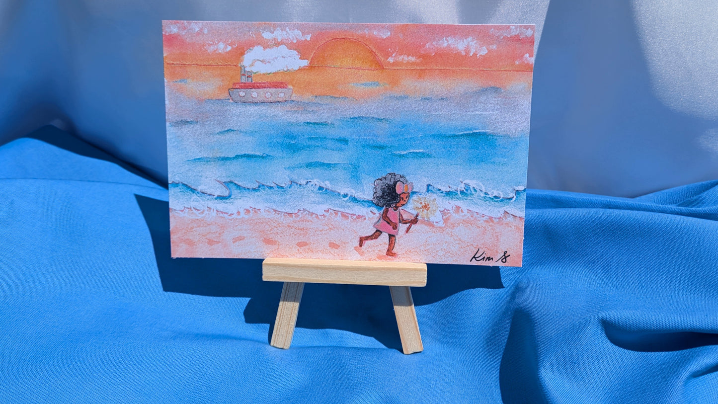 Miniature painting of a beach scene with a child on a small easel against a blue fabric background.